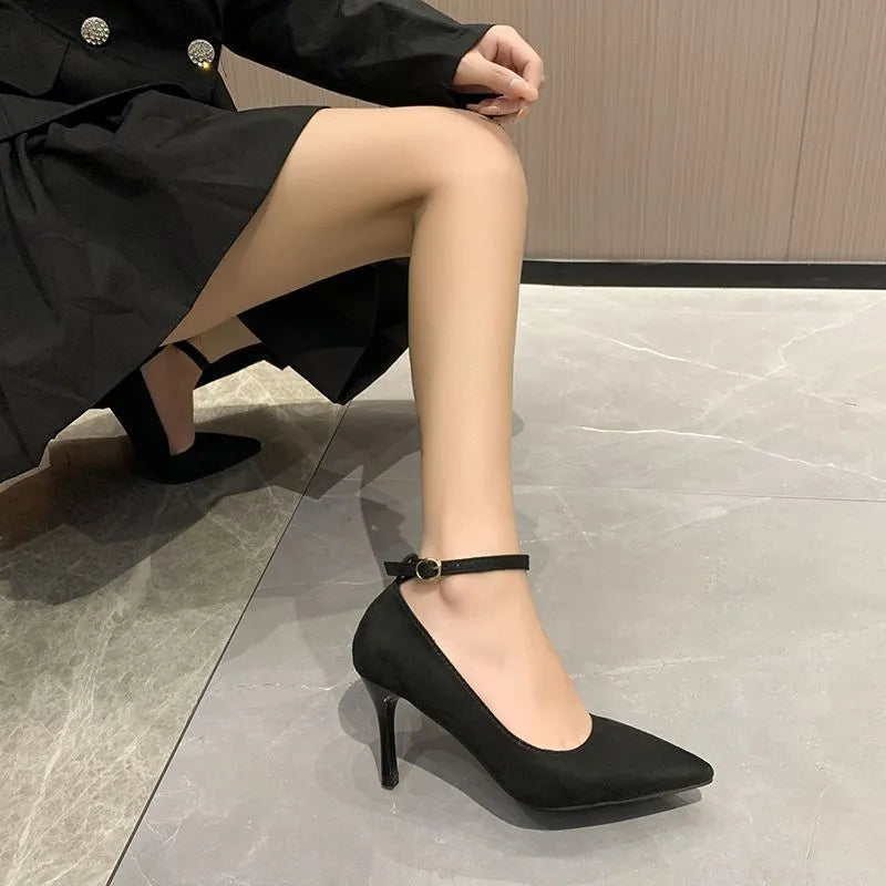 Women's black stiletto pump with ankle buckle detail and a rubber sole.