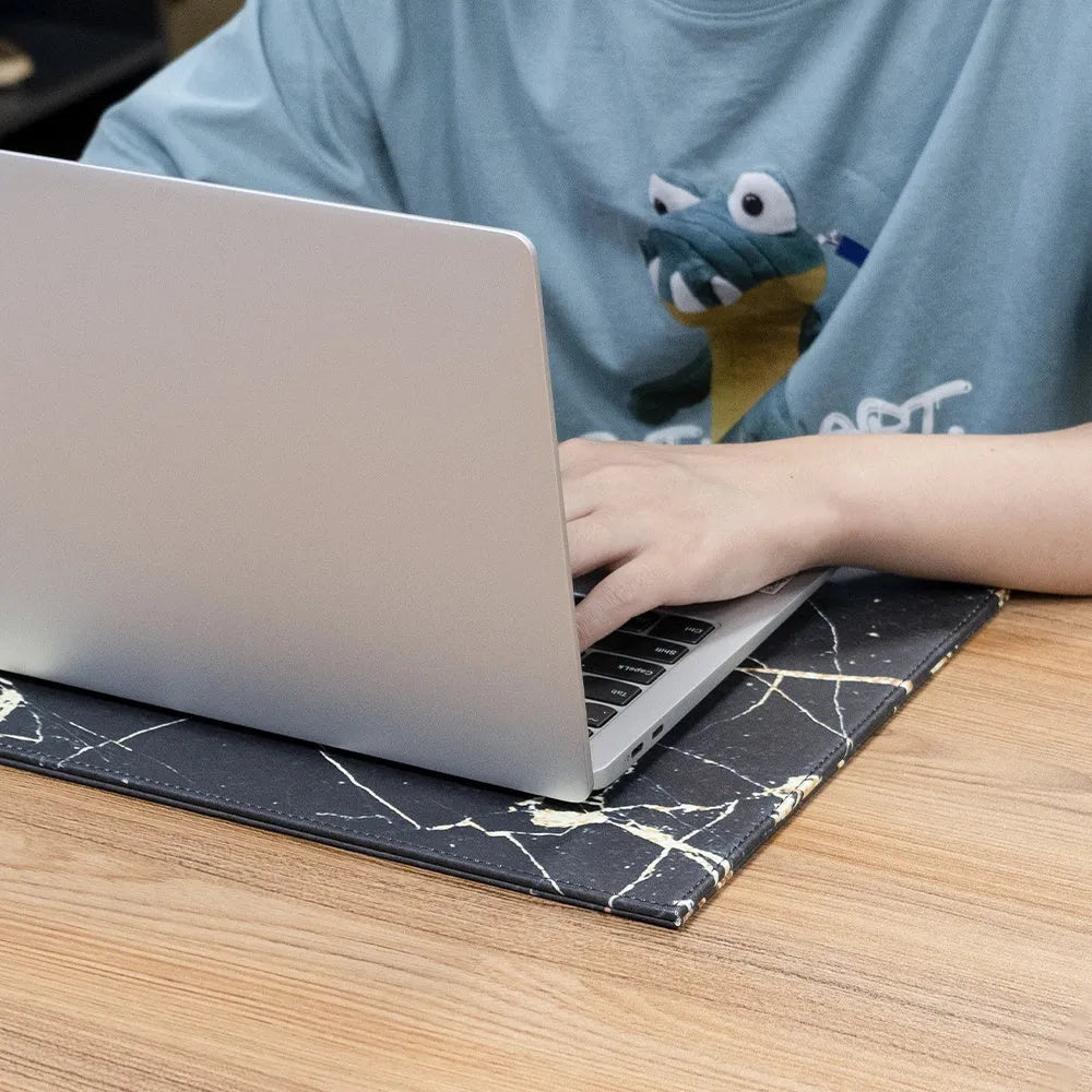 A heat-insulating anti-radiation tablet pad in blue colour with a non-slip base, placed under a laptop.
