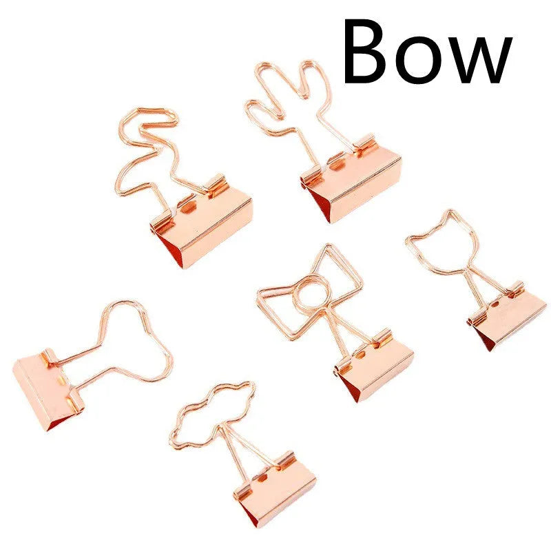 Gold long tail metal clip with decorative charm shape for document organisation