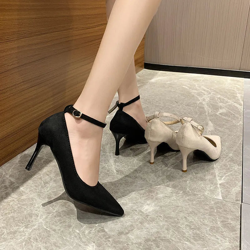 Women's black stiletto pump with ankle buckle detail and a rubber sole.