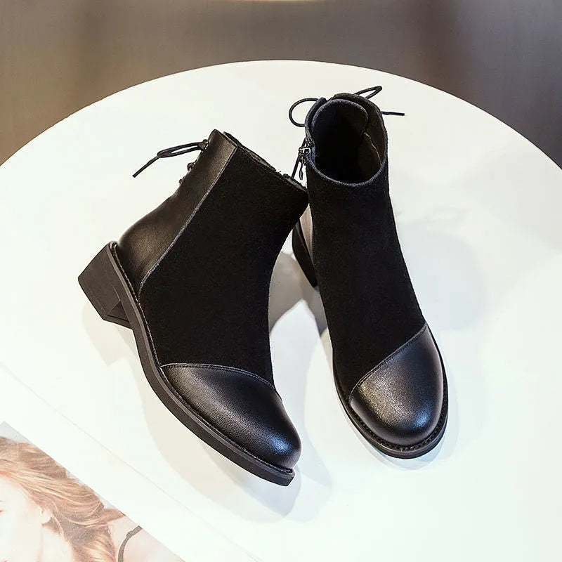 Black women's knee-high Martin boots with a bow detail and side zip on a rubber sole.