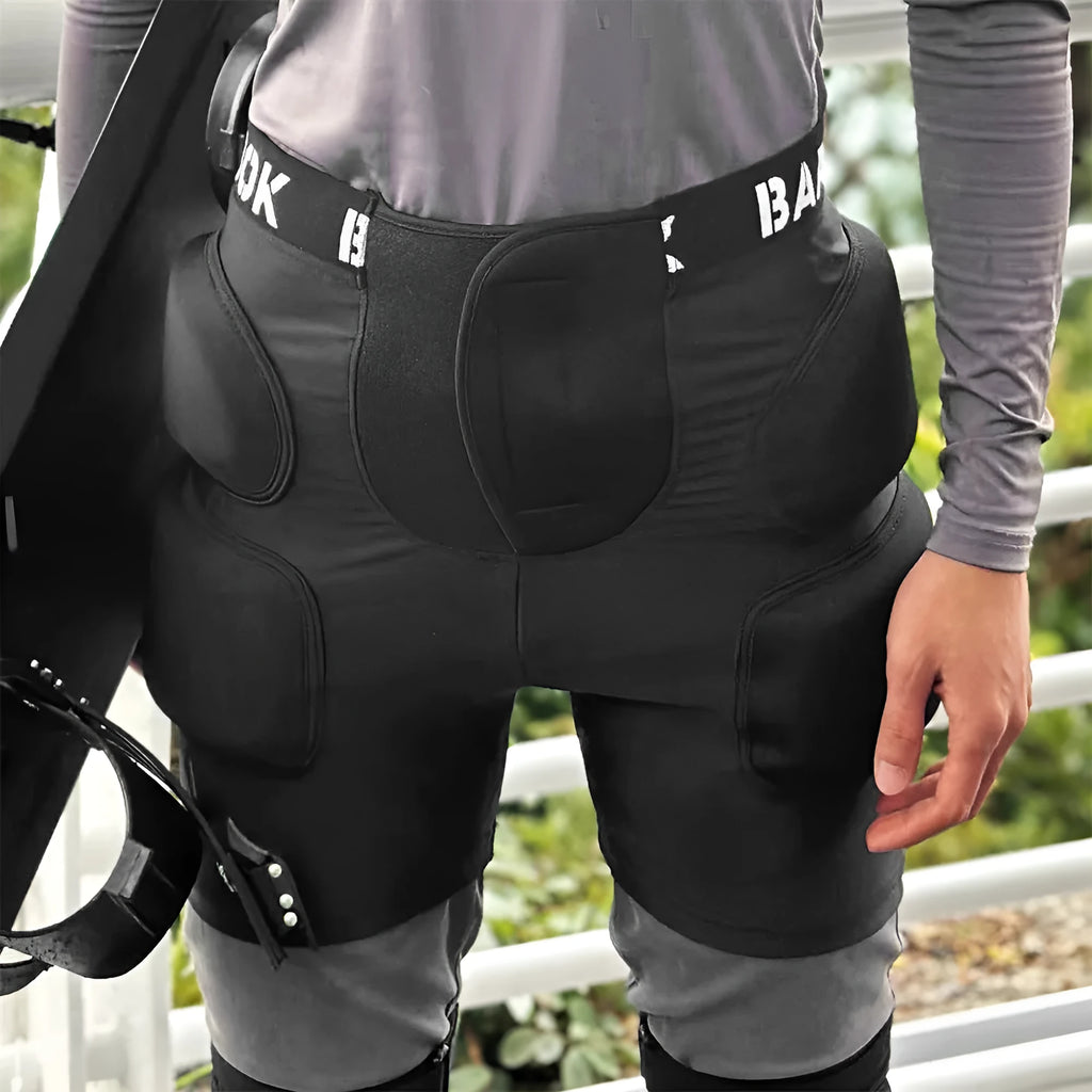 Black protective spandex trousers with integrated hip pads for skating and skateboard fall protection.