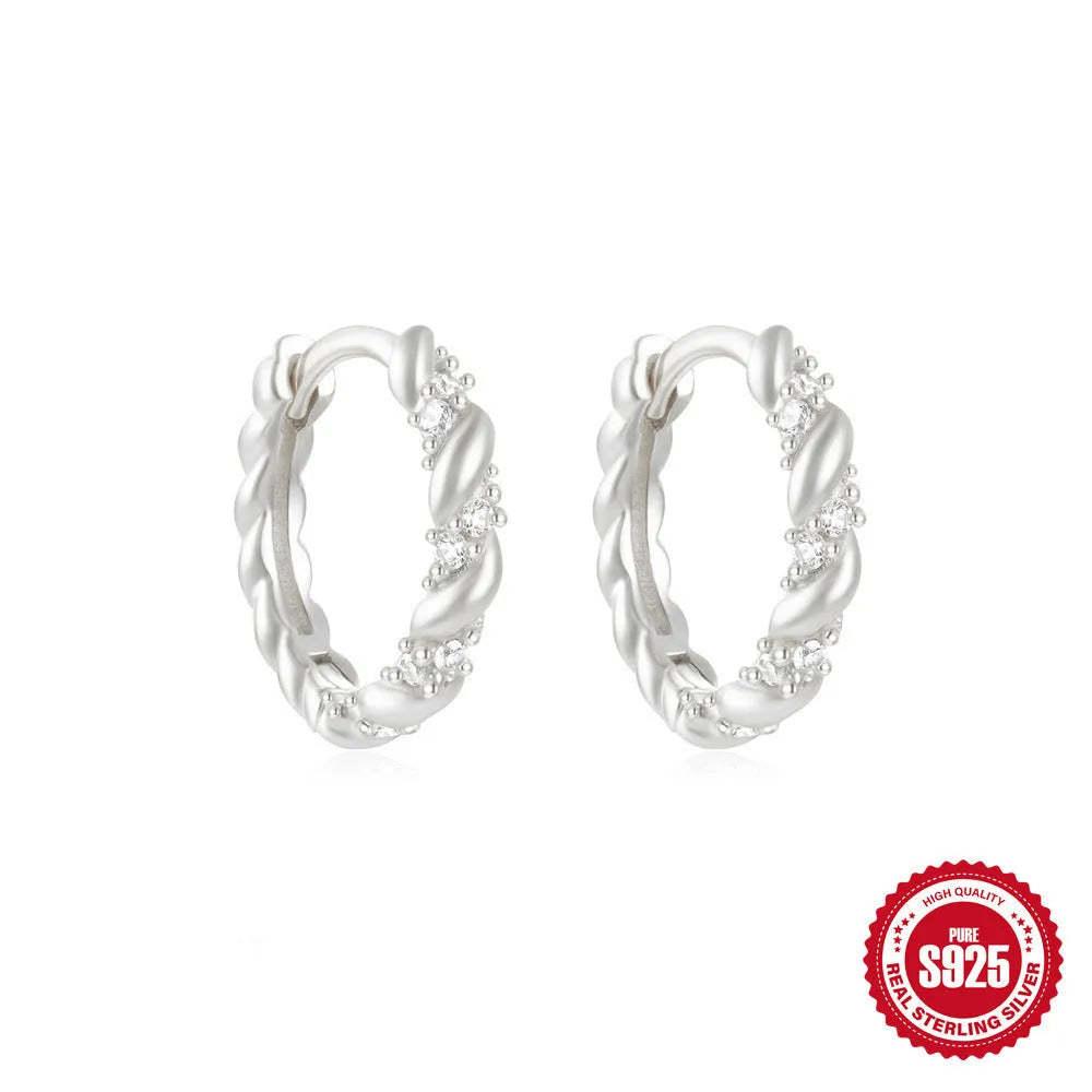 Sterling silver geometric stud earrings with a small round shape and classic diamond detail on a white background.