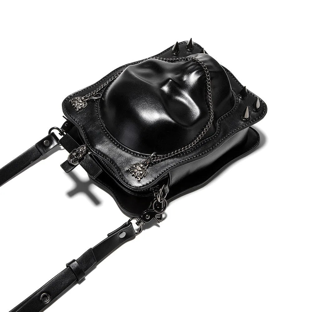 Black mini square crossbody bag with embossed skull design, decorative stitching, rivets, and chain details.