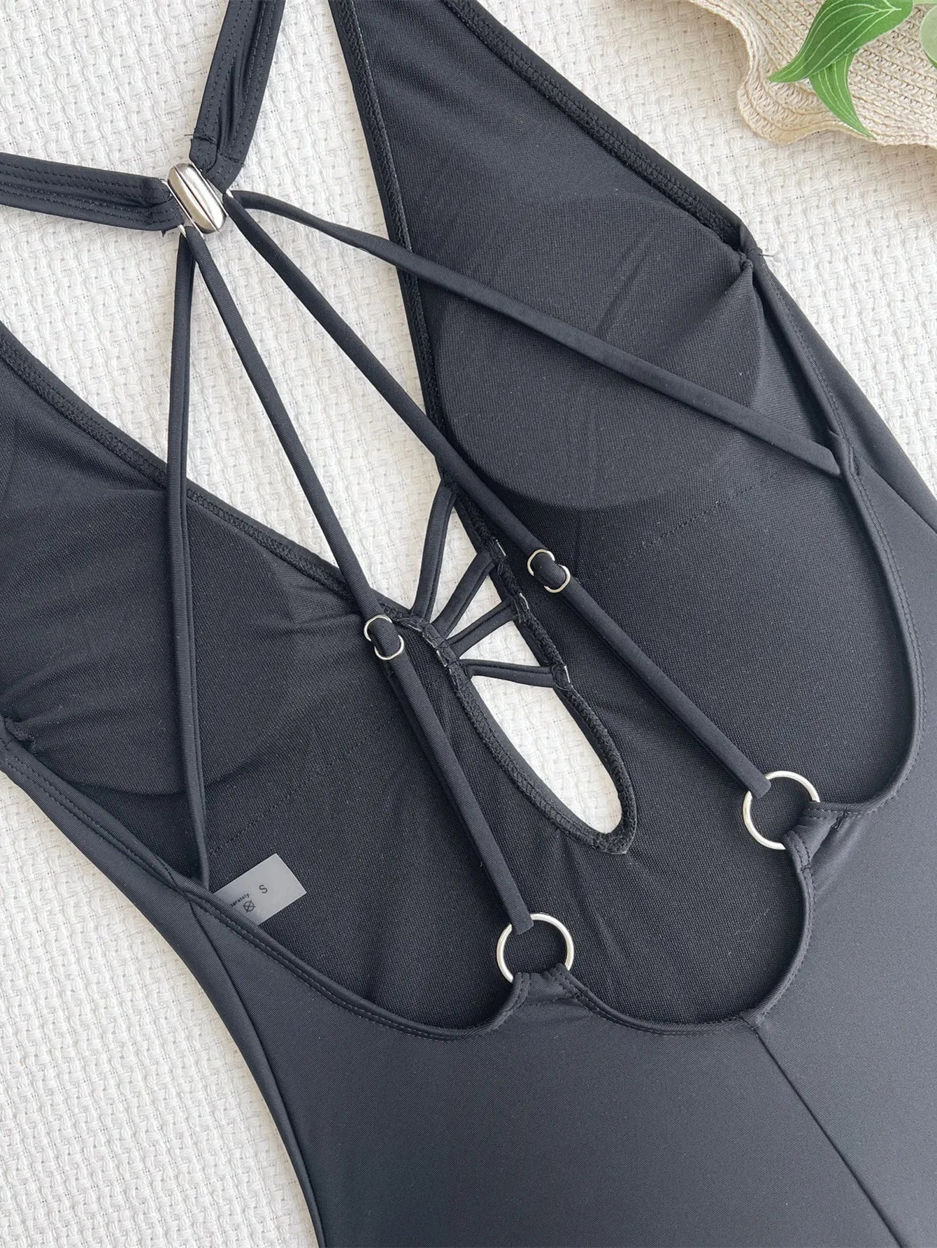 Women's solid black one-piece nylon bikini swimsuit laid flat.