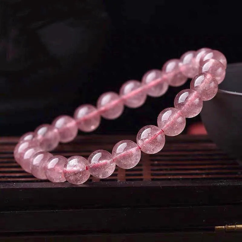 Women's strawberry quartz crystal bracelet with polished beads on an elasticated string.