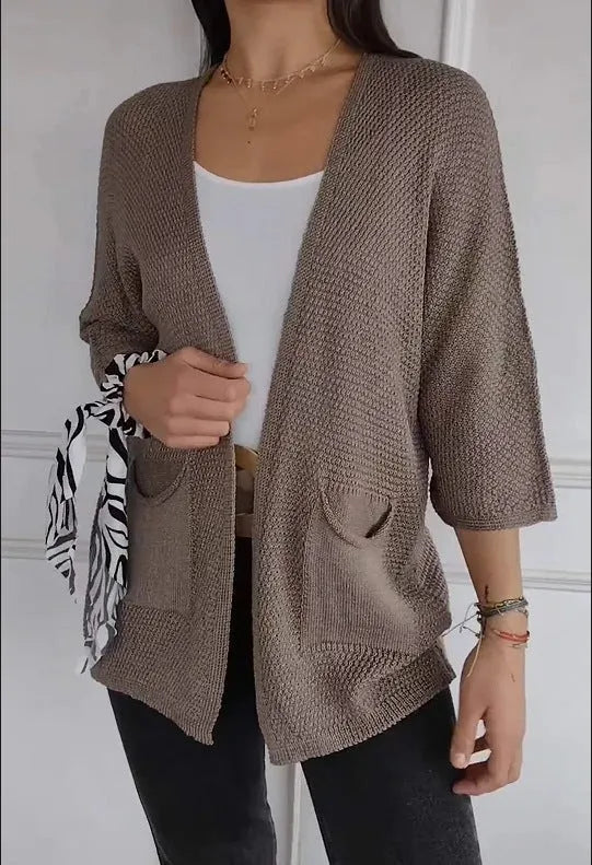 Women's thin waffle weave cardigan coat in army green with pockets, shown on a hanger.