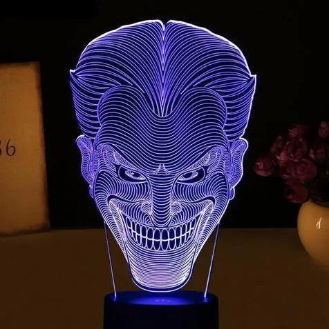 3D LED table lamp showing seven colour options with remote control and USB cable on wooden surface