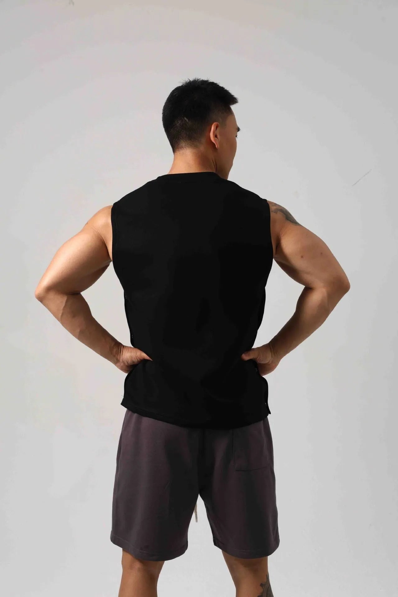 Men's black Korean style loose cotton fitness vest showing side hidden hook closure.