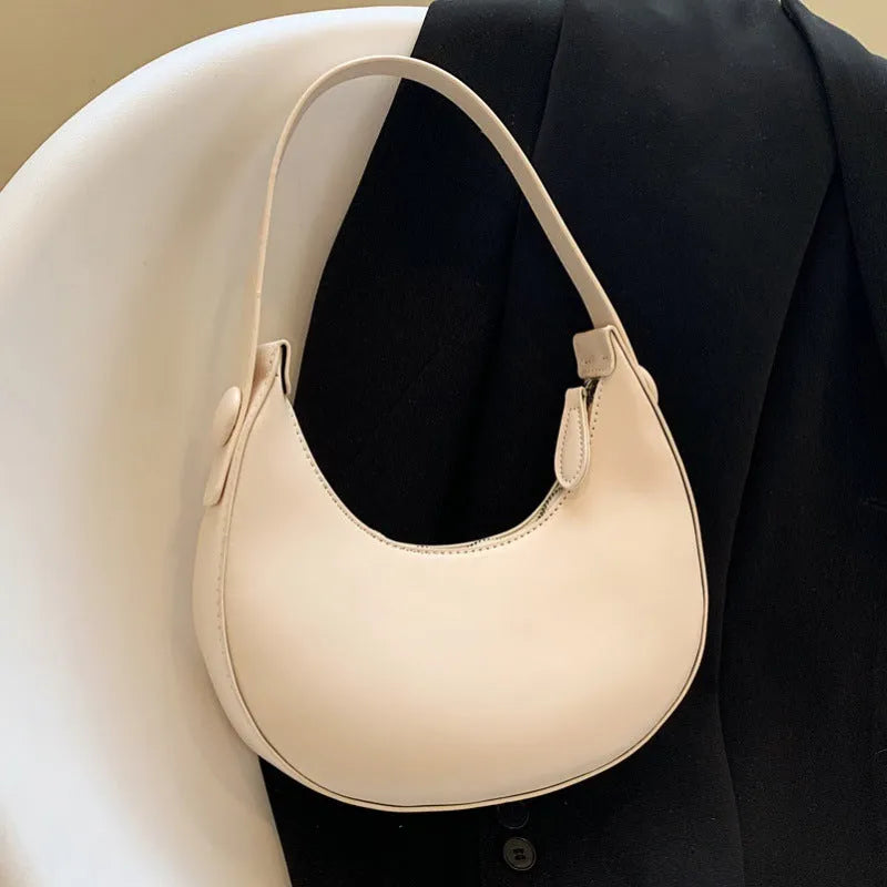 Women's retro brown dumpling-shaped PU shoulder bag showing front pocket and crossbody strap.