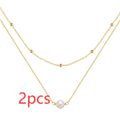 S925 sterling silver double layer necklace with twin pearls in gold or white gold finish featuring geometric pendant and ball bead chain.