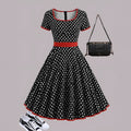 Multicolour polka dot dress with square collar, short sleeves, zip front, and pleated mid-length skirt.