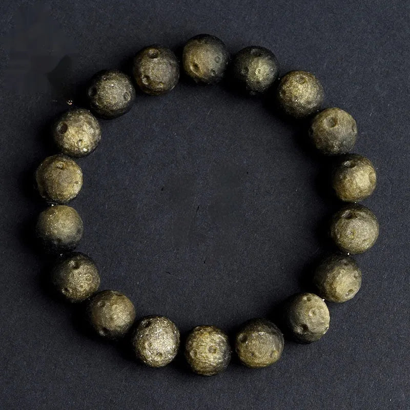 Natural obsidian crater ball bracelet with polished beads in silver or gold meteorite finish.