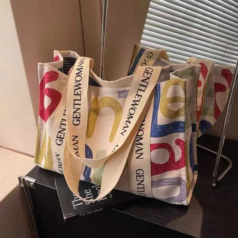 Large canvas women's travel tote bag with print design options including black letters and patterns.