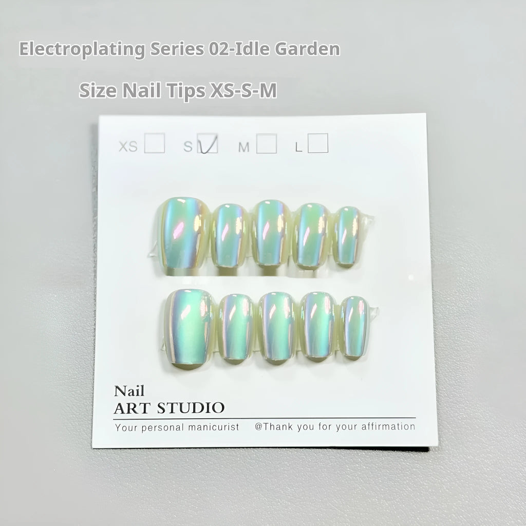 Electroplated cat's eye false nails with aurora colours in short ladder lengths on a hand.