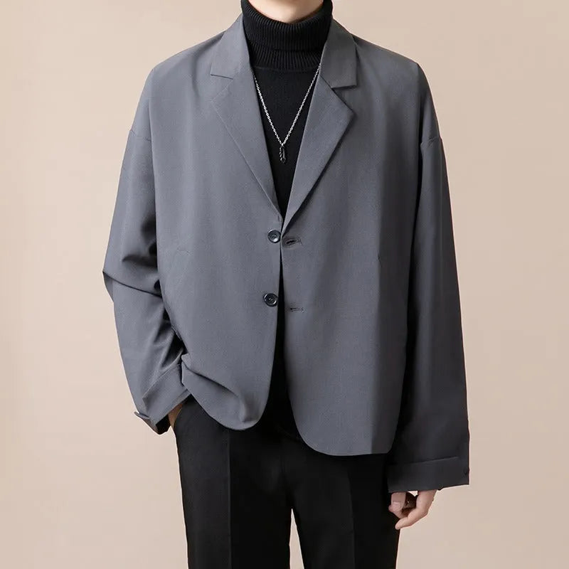A man wearing a loose-fit casual suit jacket in a light colour, suitable for smart-casual occasions.
