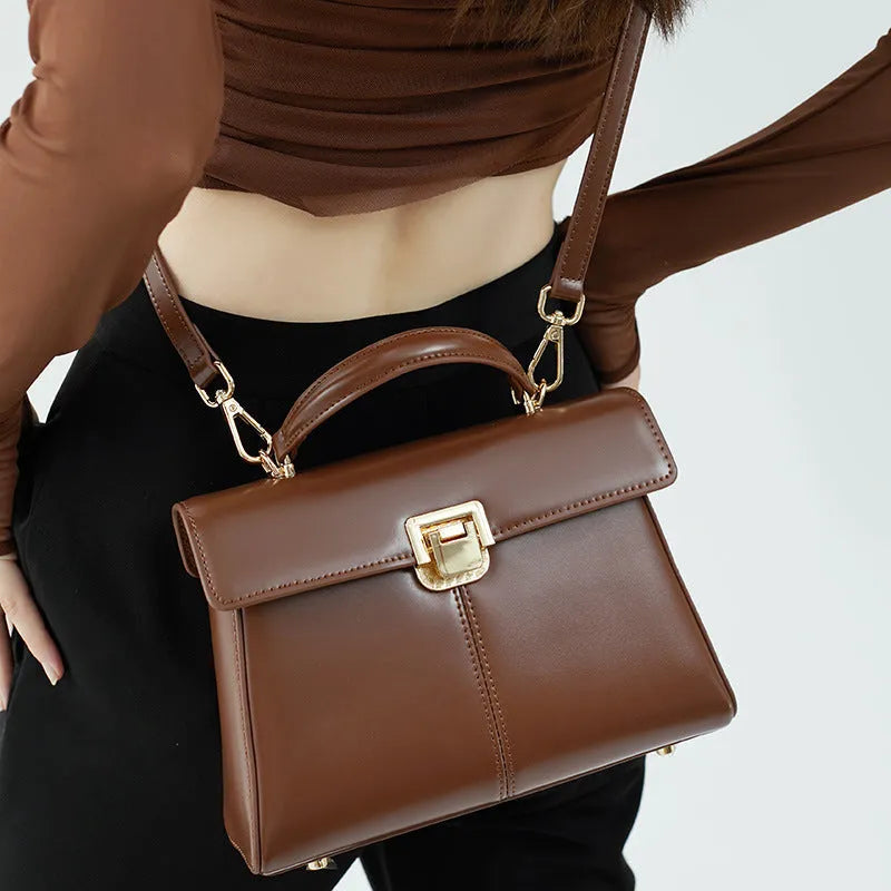 Women's black genuine leather shoulder bag with vachette clasp closure showing horizontal square design