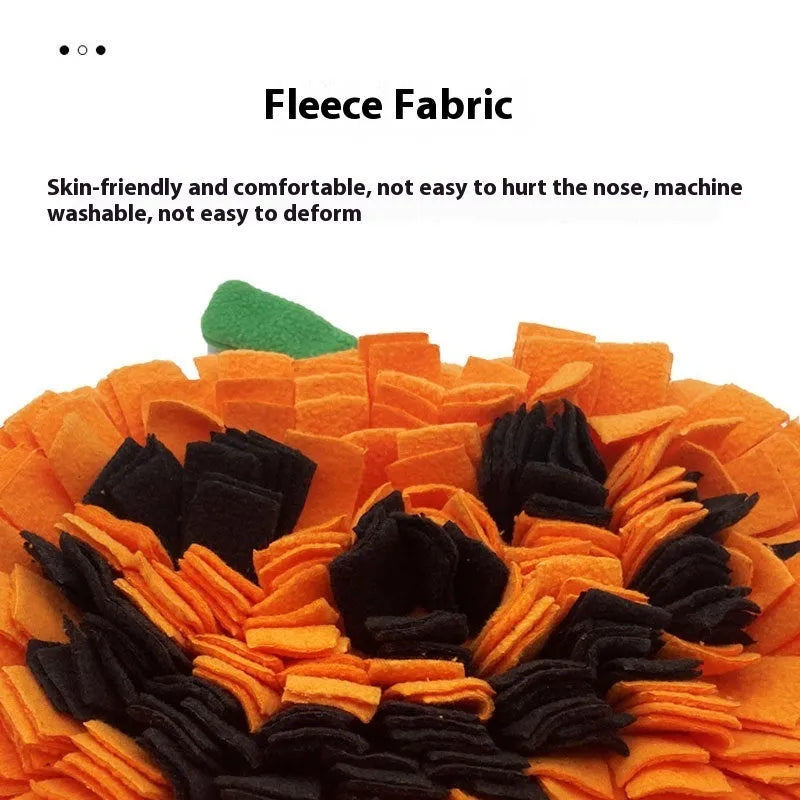 Orange pumpkin-shaped pet training mat on floor with dog treats scattered across polar fleece surface