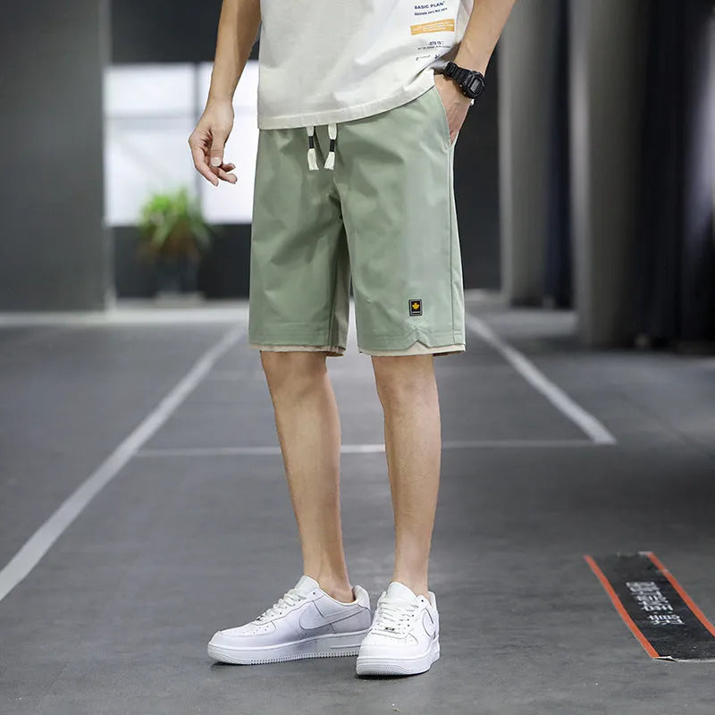 Man wearing loose-fit green casual beach shorts in a South Korea style, showing the straight cut and relaxed fit.