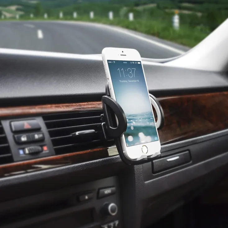 Black plastic universal mobile phone holder attached to a car air vent.