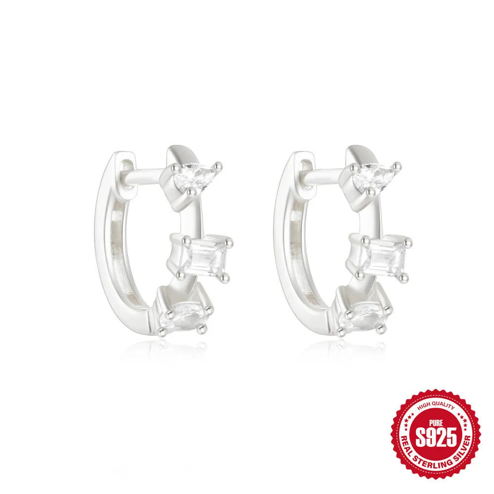 Sterling silver geometric stud earrings with a small round shape and classic diamond detail on a white background.