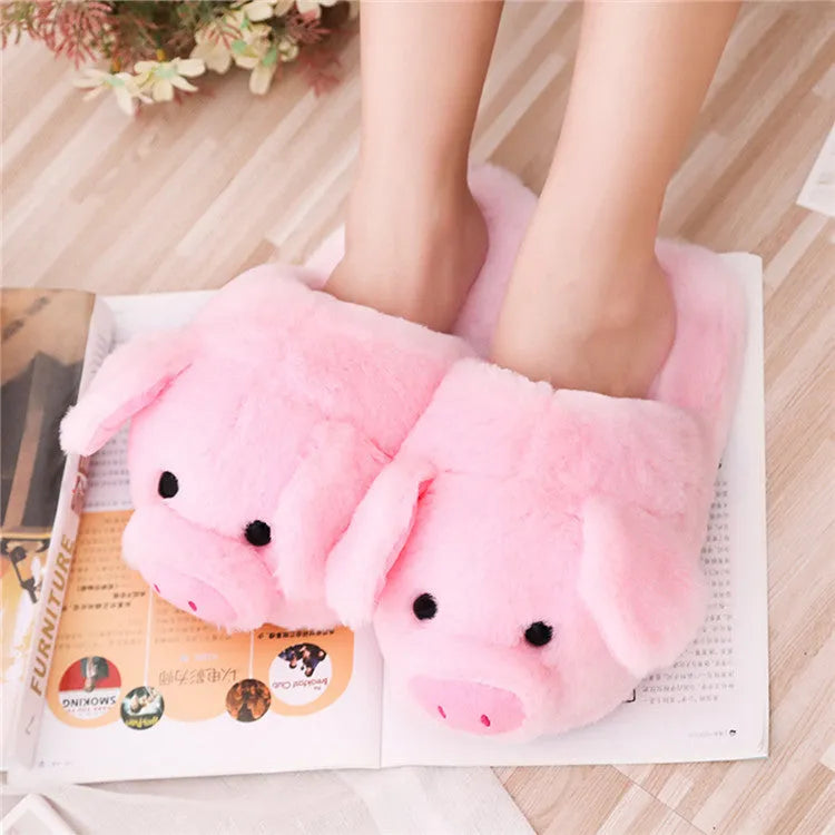 Pink pig-shaped plush slippers for adults on a white background.