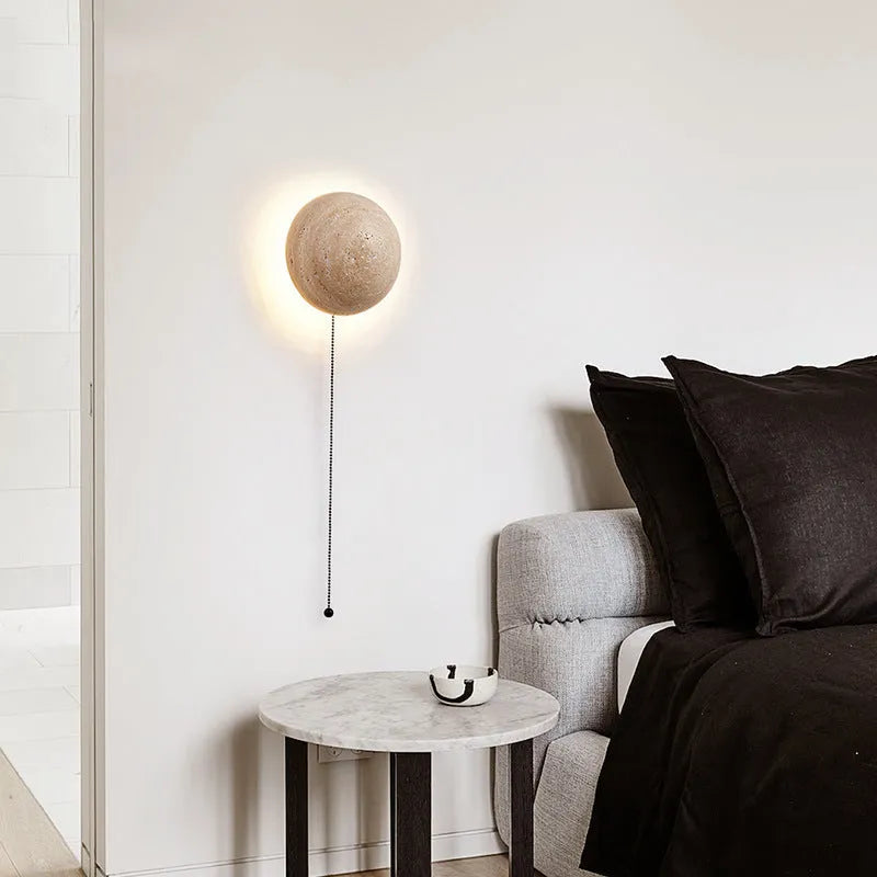 Vintage semicircle wall lamp with yellow cave stone shade and black iron frame mounted on a wall.
