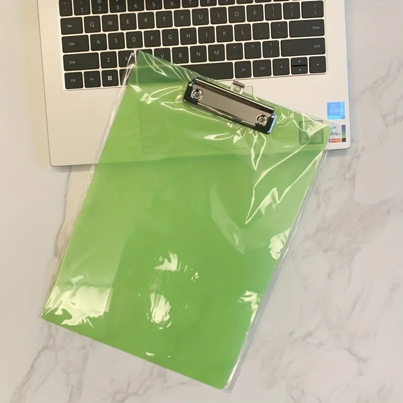 A4 transparent plastic writing board pad with metal clip in blue colour on a desk