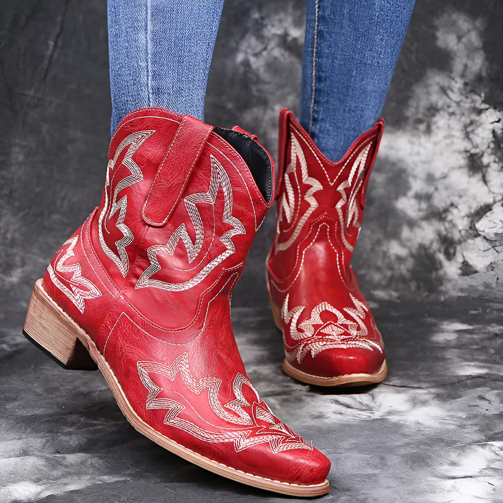 Blue women's cowboy boots with floral embroidery, a wedge heel, and a pointed toe.