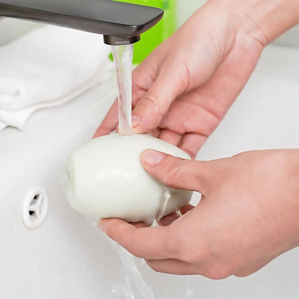 Green and white reusable gel lint roller ball for portable pet hair removal.