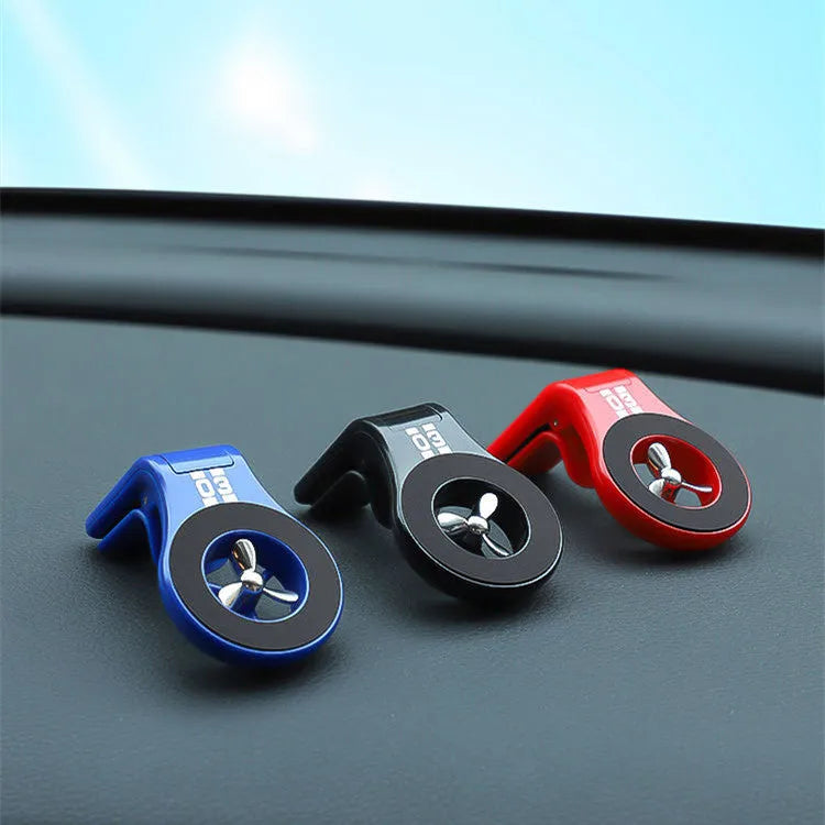 Magnetic car air vent phone holder with perfume dispenser in black, showing phone attached and fragrance slot.