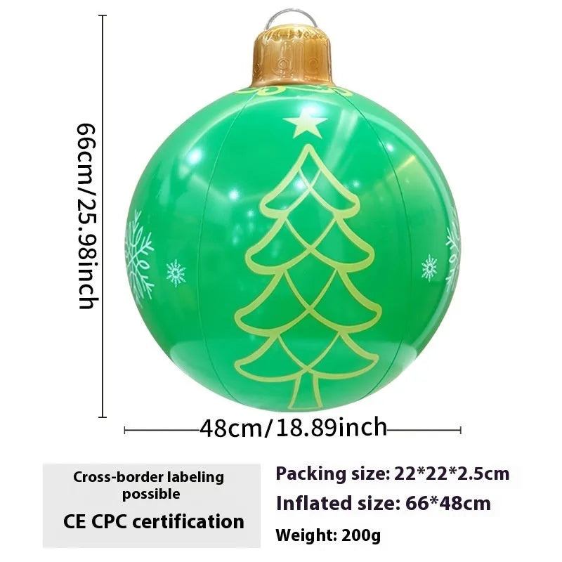 Large red inflatable Christmas ball with snowflake pattern and flash light, shown with a hand pump in a garden setting.