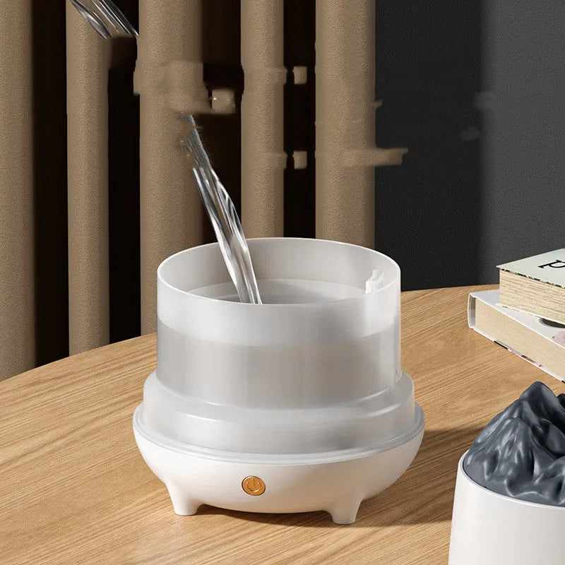 White volcano-shaped ultrasonic humidifier with USB cable on a wooden table.
