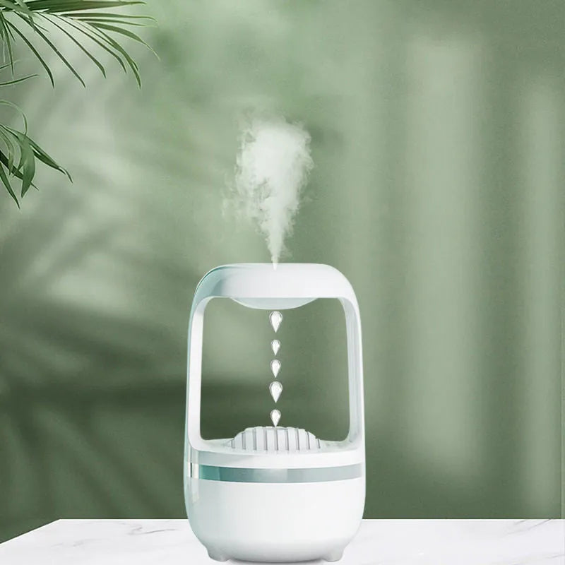 Black or white anti-gravity humidifier with water droplet effect on a desk.