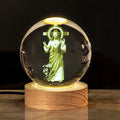 White crystal ball ornament with wood base and warm light, showing detailed internal design.