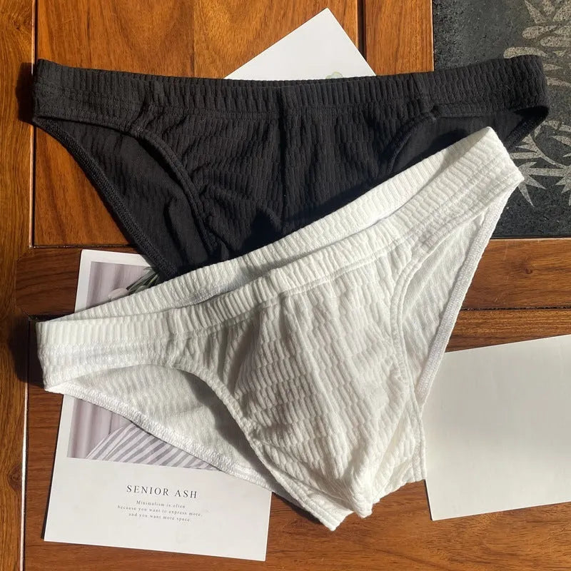 Men's solid colour cotton triangle briefs with a mid-waist waistband on a white background.
