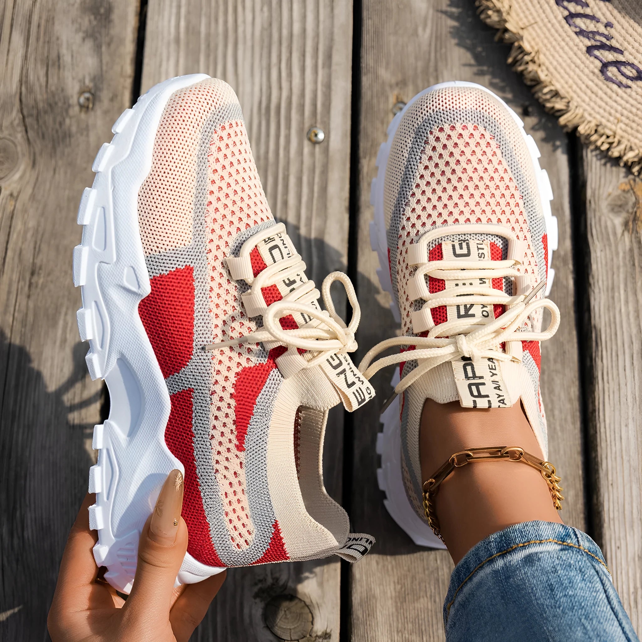 Women's Flyknit mesh lace-up sneakers in a grey colourway on a flat rubber sole.