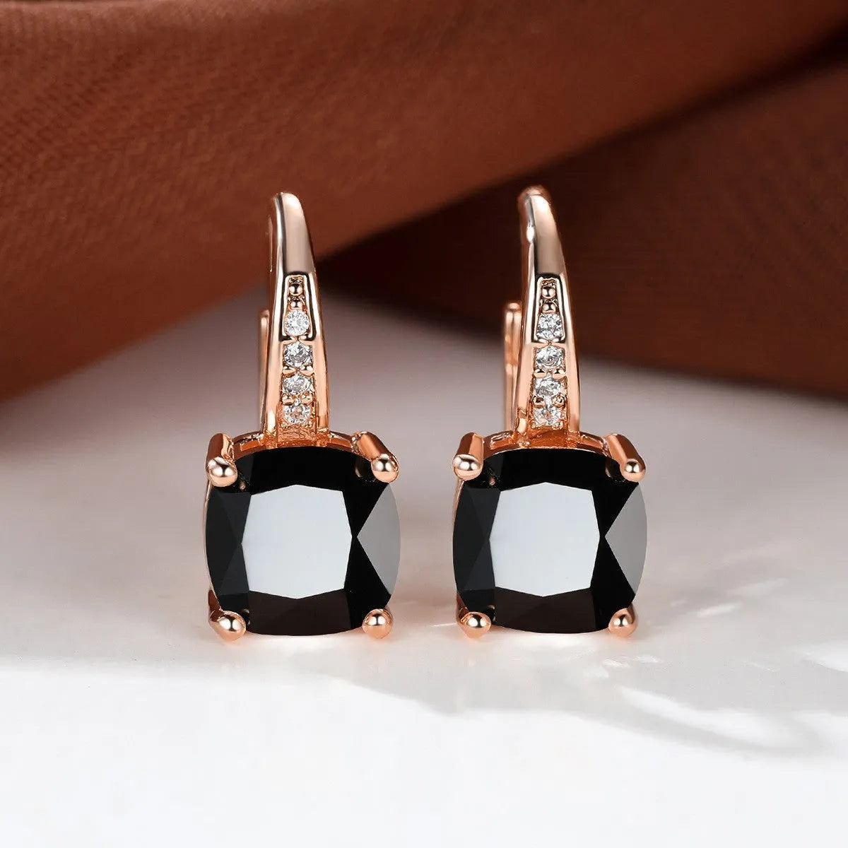 Square geometric ear hook earrings with zircon stones in an electroplated copper setting.