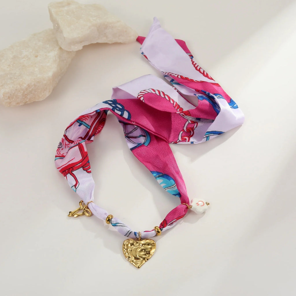 Gold-plated geometric love pendant necklace and matching bracelet jewellery set on display