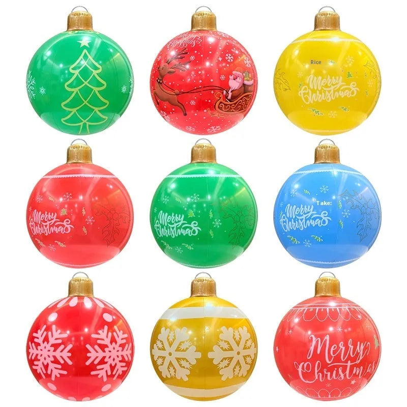 Large red inflatable Christmas ball with snowflake pattern and flash light, shown with a hand pump in a garden setting.