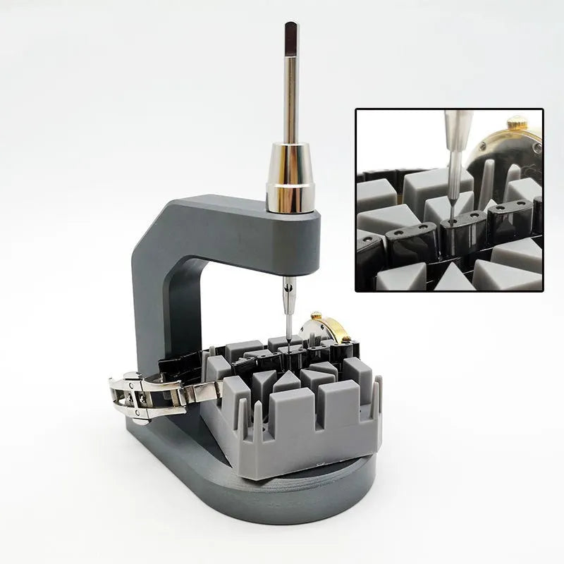 Silver tool steel multi-purpose press strap removal tool for watches and electronics on a workshop surface.