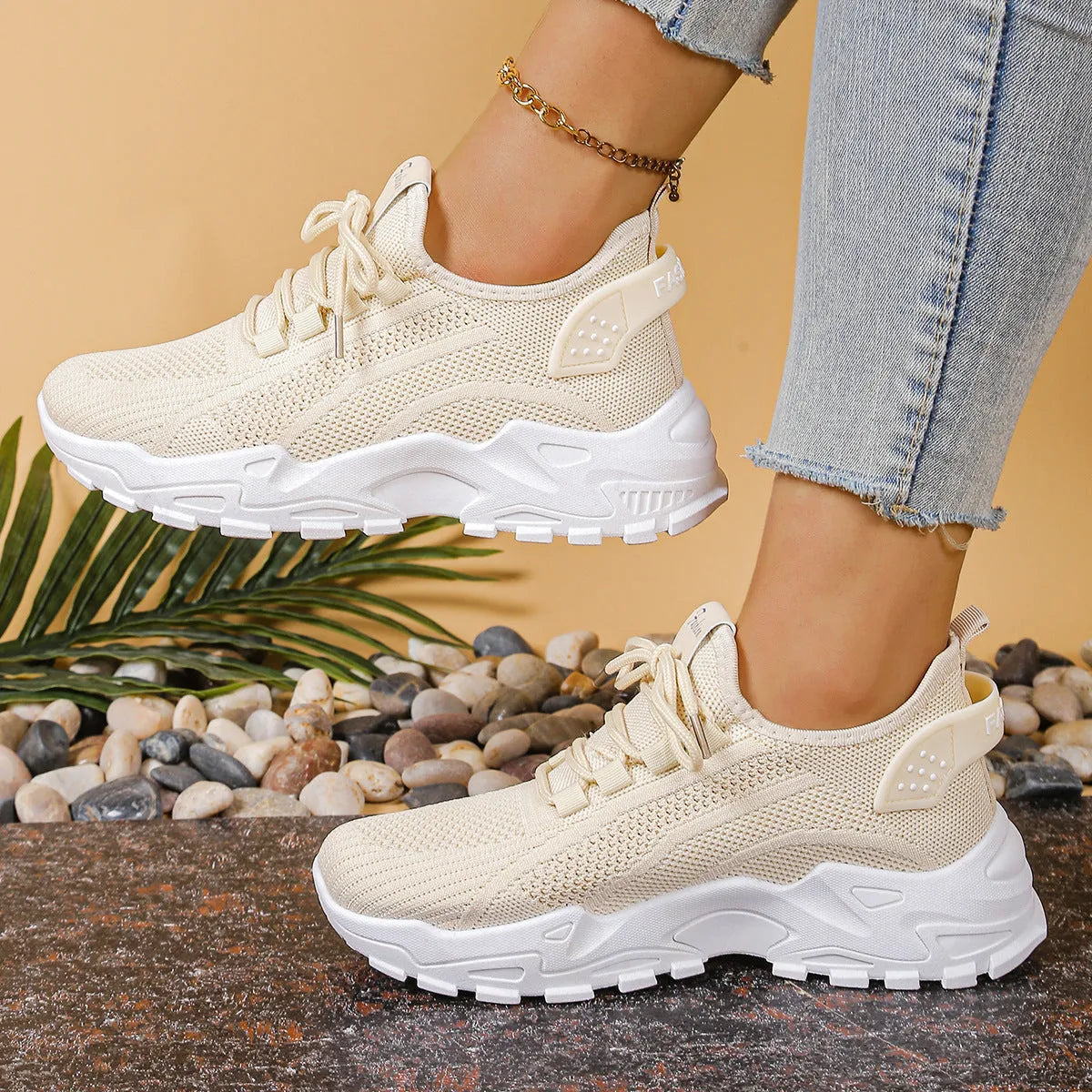 Women's low-top mesh sports sneakers in beige with front lace-up and a subtle platform sole.