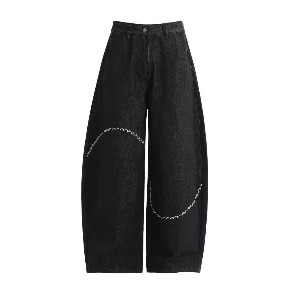Black straight-leg denim trousers on a hanger, showing mid waist and zip placket detail.