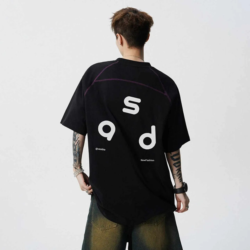 Man wearing a black loose-fit cotton T-shirt with a letter print on the chest.