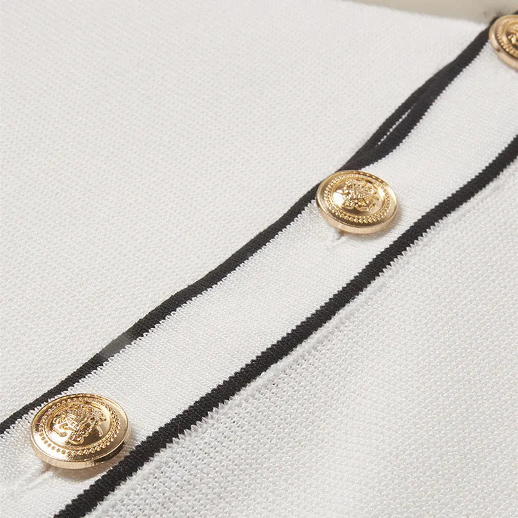 White short-sleeved cardigan with dark contrast lapels laid flat.