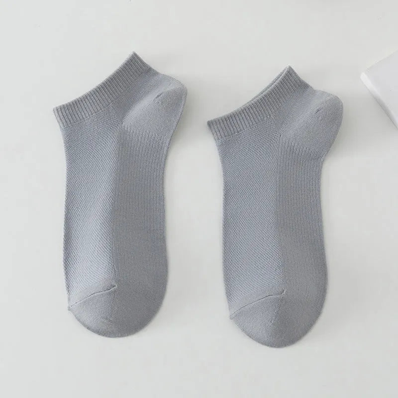 Solid colour low-cut polyester boat socks for men on a neutral background.