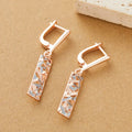 A pair of rectangular hollow stud earrings with a two-tone geometric design on a white background.