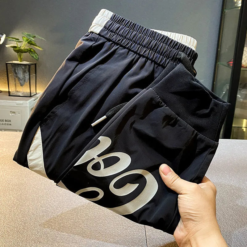Black men's cropped casual trousers with ankle band, made from ice silk cotton fabric.