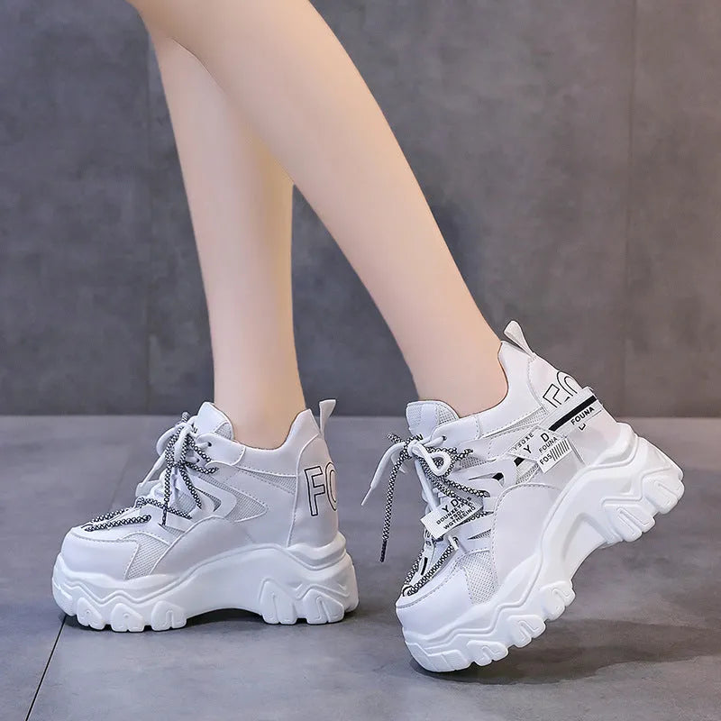 White women's mesh platform tennis shoes with cross strap and a thick rubber sole.