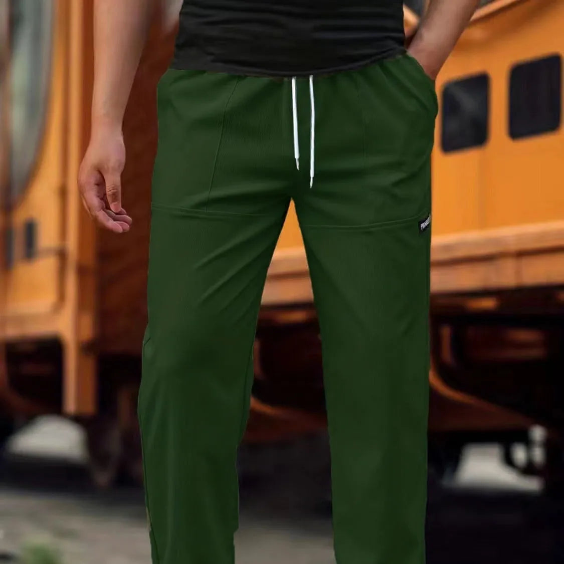Men's polyester trousers in light grey, shown laid flat, suitable for spring and autumn wear.